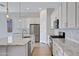 Open kitchen with stainless steel appliances, granite countertops, and bright white cabinetry at 22443 E Munoz St, Queen Creek, AZ 85142