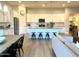 Open-concept kitchen and dining area featuring white cabinets, stainless steel appliances, and a large island at 22443 E Munoz St, Queen Creek, AZ 85142