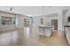 Open-concept kitchen featuring an island, stainless steel appliances, pendant lighting, and wood floors at 22443 E Munoz St, Queen Creek, AZ 85142