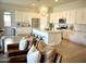 Open-concept kitchen featuring white cabinets, stainless steel appliances, large island, and hardwood floors at 22443 E Munoz St, Queen Creek, AZ 85142