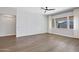 Spacious living room featuring wood floors, decorative wall and a modern ceiling fan at 22443 E Munoz St, Queen Creek, AZ 85142