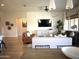 Bright open living space featuring hardwood floors, modern lighting, a large TV, and comfortable seating arrangements at 22443 E Munoz St, Queen Creek, AZ 85142