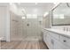 Bathroom with glass enclosed shower, white cabinets, and wood-look tile flooring at 2260 E Warbler Rd, Gilbert, AZ 85297