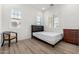 Well-lit bedroom with wood-style floors, white walls, a modern bed, and shuttered windows at 2260 E Warbler Rd, Gilbert, AZ 85297