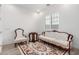 Cozy living room featuring white walls, wood floors, vintage furniture, and a window at 2260 E Warbler Rd, Gilbert, AZ 85297