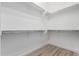 Bright walk-in closet featuring white walls, built-in shelving, and wood-style floors at 2260 E Warbler Rd, Gilbert, AZ 85297