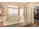 A soaking tub with a window and tiled walls is the focal point of this bathroom at 2324 W Melody Dr, Phoenix, AZ 85041