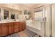 Bathroom offers a dual sink vanity, a large mirror, soaking tub, and tile floors at 2324 W Melody Dr, Phoenix, AZ 85041