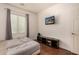 Bedroom with a window, hardwood floors, and a TV on the wall at 2324 W Melody Dr, Phoenix, AZ 85041