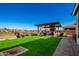 Expansive backyard featuring lush grass, a covered patio, and space for outdoor enjoyment at 24578 W Concorda Dr, Buckeye, AZ 85326