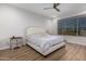 Bright bedroom featuring a ceiling fan, wood floors, large window and tasteful, neutral decor at 24578 W Concorda Dr, Buckeye, AZ 85326