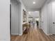 Bright hallway featuring hardwood floors, white walls, and modern decorations at 24578 W Concorda Dr, Buckeye, AZ 85326