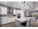 Modern kitchen featuring stainless steel appliances, white cabinetry, tile backsplash, and an island with bar stool seating at 24578 W Concorda Dr, Buckeye, AZ 85326