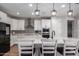 Bright kitchen featuring a large island with seating, white cabinets, modern appliances, and decorative backsplash at 24578 W Concorda Dr, Buckeye, AZ 85326