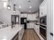 Spacious kitchen with white cabinets, stainless steel appliances, a large island, and an open view to the staircase at 24578 W Concorda Dr, Buckeye, AZ 85326