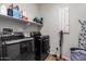Well-equipped laundry room with modern washer, dryer, shelving, and convenient ironing board at 24578 W Concorda Dr, Buckeye, AZ 85326
