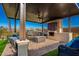Inviting covered outdoor kitchen featuring a built-in grill, fireplace and comfortable seating at 24578 W Concorda Dr, Buckeye, AZ 85326