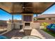 Inviting covered outdoor kitchen featuring a built-in grill, fireplace and comfortable seating at 24578 W Concorda Dr, Buckeye, AZ 85326