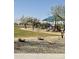 Community playground with slides and play structures surrounded by desert landscaping and shade canopies at 24578 W Concorda Dr, Buckeye, AZ 85326