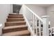 Carpeted staircase with white railing leads to upper level, offering a glimpse of open floorplan at 24578 W Concorda Dr, Buckeye, AZ 85326
