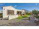 Private backyard featuring an outdoor kitchen, gravel, artificial grass, lush landscaping, and patio space at 25925 W Mcrae Dr, Buckeye, AZ 85396