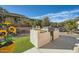 Outdoor kitchen with a stone counter with built-in grill and artificial grass in a landscaped backyard at 25925 W Mcrae Dr, Buckeye, AZ 85396