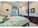 Traditional bedroom featuring a floral bedspread, dark wood furniture, and natural light from the window at 25925 W Mcrae Dr, Buckeye, AZ 85396