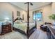 Bedroom features a four-poster bed, soft lighting, and a large window at 25925 W Mcrae Dr, Buckeye, AZ 85396