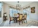 Dining room features a large window, elegant light fixture, and seating for six guests at 25925 W Mcrae Dr, Buckeye, AZ 85396