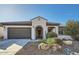 Exterior of a well-maintained home featuring a gray garage door and desert landscaping at 25925 W Mcrae Dr, Buckeye, AZ 85396