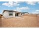 Large backyard featuring dirt, a block fence, covered patio, and a view of neighboring homes at 26361 N 76Th Dr, Peoria, AZ 85383