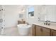 Bright bathroom featuring a soaking tub, double vanity, and glass-enclosed shower at 26361 N 76Th Dr, Peoria, AZ 85383