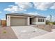Exterior view featuring a two-car garage and covered entry of home with desert landscaping at 26361 N 76Th Dr, Peoria, AZ 85383