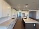 Spacious kitchen featuring an island and white cabinets and quartz countertops at 26361 N 76Th Dr, Peoria, AZ 85383