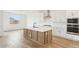 Elegant kitchen with white cabinets, quartz countertops, stainless steel appliances, and an island at 26361 N 76Th Dr, Peoria, AZ 85383