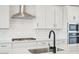 Close-up of a modern kitchen's features, including a stainless steel range hood, sink, and appliances at 26361 N 76Th Dr, Peoria, AZ 85383