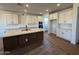 A modern kitchen boasting white cabinetry, a dark-wood island, and sleek quartz countertops for style and functionality at 26361 N 76Th Dr, Peoria, AZ 85383