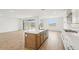 Contemporary kitchen featuring an island with seating, stainless appliances, and an adjacent living space at 26361 N 76Th Dr, Peoria, AZ 85383