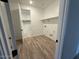 Functional laundry room featuring wood-look tile floors, shelving, and utility connections for appliances at 26361 N 76Th Dr, Peoria, AZ 85383