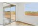 Bright room with sliding glass doors offering backyard access and mountain views from a side window at 26361 N 76Th Dr, Peoria, AZ 85383