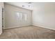 Bright bedroom with a large window, neutral colors, soft carpeting, and ceiling fan at 2820 E Tracy Ln # 1, Phoenix, AZ 85032