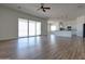 Bright, open-concept living space with wood-look floors, large windows, and modern pendant lighting over the kitchen island at 29120 N 257Th Dr, Wittmann, AZ 85361