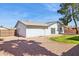 Well maintained backyard with a lawn, mature tree, gravel, and a view of the home's rear white brick exterior at 2935 W Dailey St, Phoenix, AZ 85053