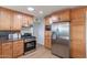 Kitchen with stainless steel refrigerator, wood cabinets, stone counters, and black oven range at 3321 E Almeria Rd, Phoenix, AZ 85008