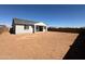 A view of the home's back exterior featuring a dirt backyard, covered patio and slider access to inside at 36805 W San Clemente St, Maricopa, AZ 85138