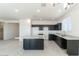 Modern kitchen features dark cabinetry, granite counters, and tile flooring at 36805 W San Clemente St, Maricopa, AZ 85138