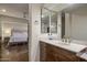 Well-lit bathroom featuring a wooden vanity and modern sink with a bedroom view at 38951 N 101St Way, Scottsdale, AZ 85262