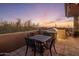 Outdoor dining area featuring a metal table set, a grill, and a desert sunset view at 38951 N 101St Way, Scottsdale, AZ 85262