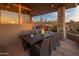 Outdoor patio space featuring a dining table, stone pillars, and desert sunset views at 38951 N 101St Way, Scottsdale, AZ 85262