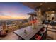 Beautiful covered patio area showcasing an outdoor dining table with mountain views at sunset at 38951 N 101St Way, Scottsdale, AZ 85262